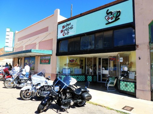 Exterior of the Bisbee Breakfast Club with parked motorcycles in front and a colorful sign above the entrance.
