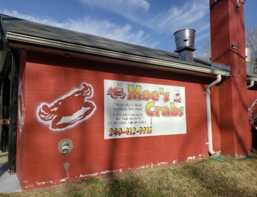 A red building with a sign that reads "Moe's Crabs" featuring a crab graphic and contact information.