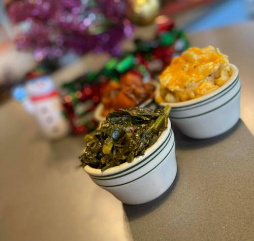 Two small bowls of food: one with collard greens and the other with macaroni and cheese, set against a festive background.