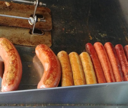 A variety of cooked sausages arranged on a grill, showcasing different colors and sizes.
