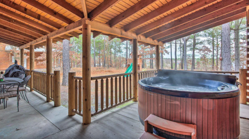 A wooden porch with a hot tub, surrounded by trees and a peaceful outdoor setting.