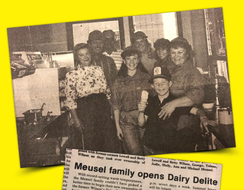 A group photo of the Meusel family and staff at Dairy Delite, smiling in a retro diner setting.