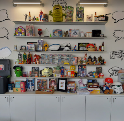 A colorful display of toys, collectibles, and memorabilia on shelves, featuring superheroes, games, and various characters.