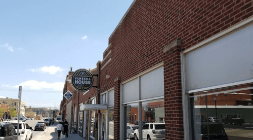 Exterior view of a brick building with a sign for "Vanessa House" and clear blue skies above.