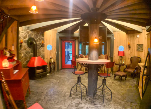 Cozy interior with a circular design, featuring a bar, stone walls, and warm lighting.