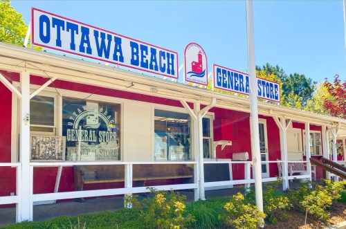 Exterior of Ottawa Beach General Store, featuring a red facade and white trim, with a sign above the entrance.
