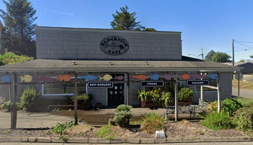 Exterior of Blackfish Cafe, featuring a sign and colorful fish decorations, with a focus on burgers, steaks, and salmon.