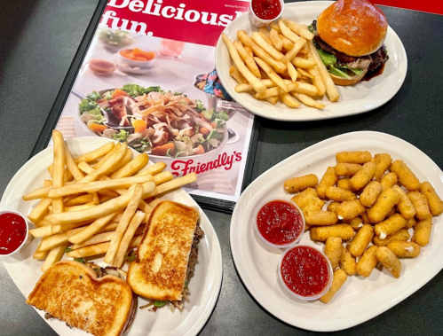 Three plates of food featuring fries, a burger, a grilled sandwich, and mozzarella sticks with dipping sauce.