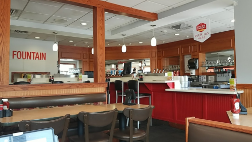 Interior of a diner with wooden accents, a fountain drink station, and a counter in the background.