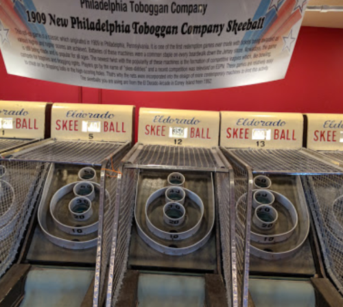 A vintage skeeball game setup with multiple lanes and scoring rings, under a banner for the Philadelphia Toboggan Company.