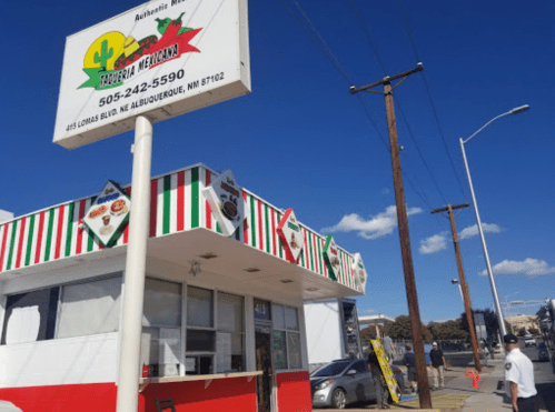 A colorful Mexican restaurant with a sign, located on a sunny street in Albuquerque, NM.