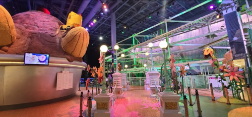 Colorful indoor amusement area featuring large whimsical structures and vibrant decorations.
