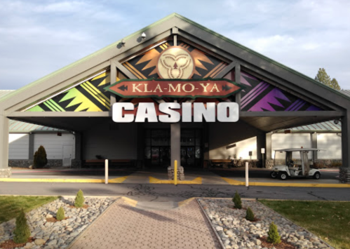 Entrance of Kla-Mo-Ya Casino featuring a large sign and colorful design, with a golf cart parked nearby.
