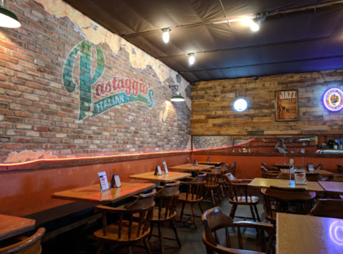 Cozy Italian restaurant interior with brick walls, wooden tables, and a warm ambiance. Jazz-themed decor visible.