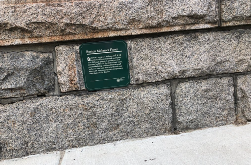 Plaque on a stone wall detailing the Boston Molasses Flood event.