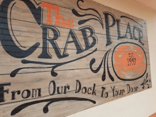 Sign for "The Crab Place," established 1997, with the tagline "From Our Dock To Your Door."