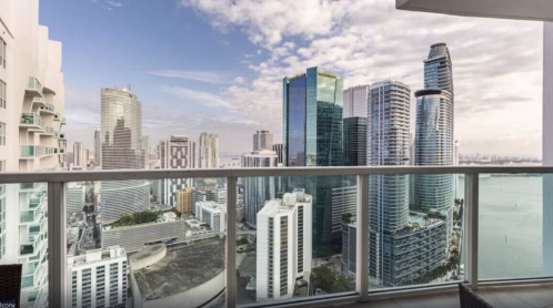 A panoramic view of a city skyline featuring modern skyscrapers and a cloudy sky.