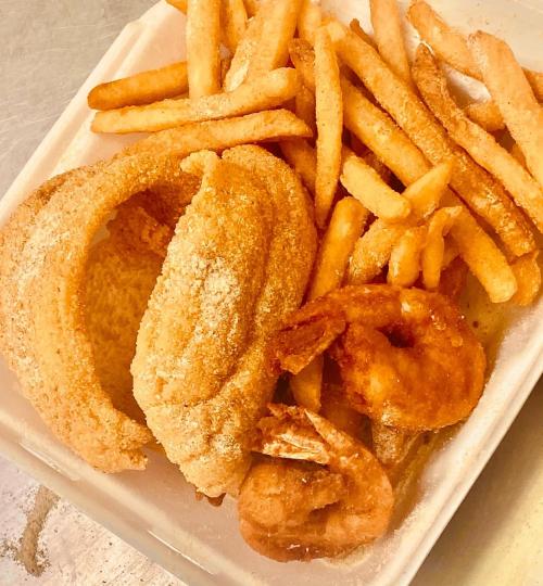 A plate of golden fried shrimp, two hush puppies, and a serving of crispy French fries.