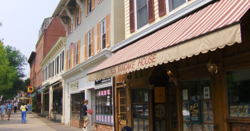 A street view featuring P's Pancake House with striped awning, surrounded by historic buildings and pedestrians.