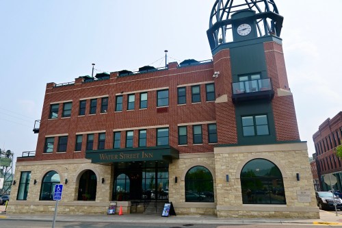 Exterior view of the Water Street Inn, featuring a clock tower and arched windows, set in a brick building.