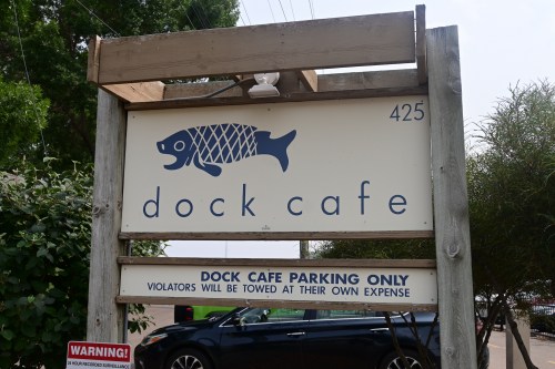 Sign for Dock Cafe with a fish graphic, stating "Dock Cafe Parking Only" and towing warning. Address: 425.