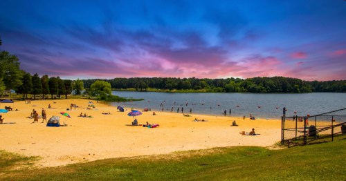 families spending time in the water and on the sand at ackworth beach, cauble park georgia