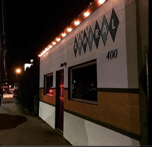 A nighttime view of a building with the sign "The Admiral" and the number 400, illuminated by streetlights.