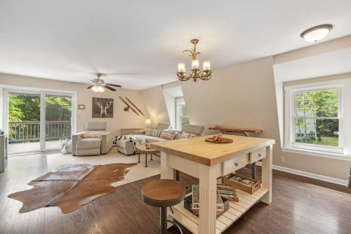 Cozy living space with a wooden island, comfortable seating, and large windows overlooking greenery.