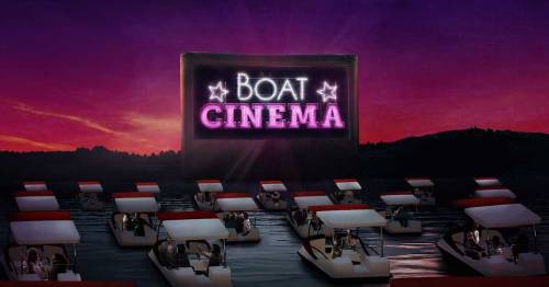 A vibrant sunset scene featuring multiple boats on water, with a large "Boat Cinema" sign illuminated in the background.