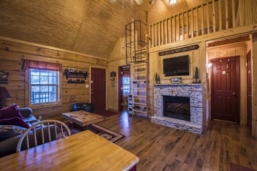 Cozy wooden cabin interior with a spiral staircase, stone fireplace, and rustic furnishings. Warm and inviting atmosphere.