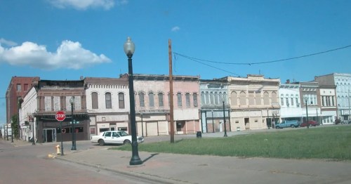 A row of historic brick storefronts with boarded-up windows in Cairo, Illinois.