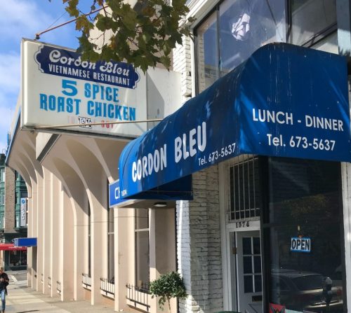 Sign for Cordon Bleu Vietnamese Restaurant featuring "5 Spice Roast Chicken" and blue awning, with a street view.