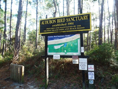 Sign for Audubon Bird Sanctuary, established in 1961, with a map and rules posted in a wooded area.
