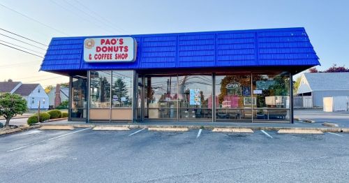 Exterior of Pao's Donuts & Coffee Shop, featuring a blue roof, large windows, and an "OPEN" sign. Parking lot visible.