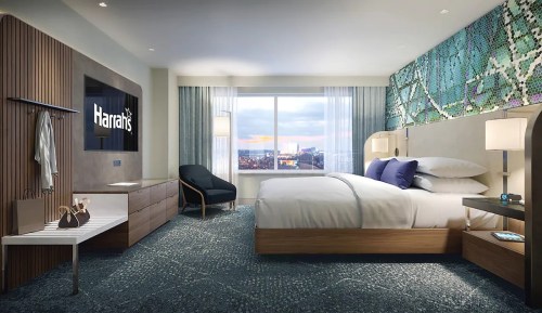 Modern hotel room featuring a king bed, large window with city view, and stylish furnishings. Harrah's logo on the TV.