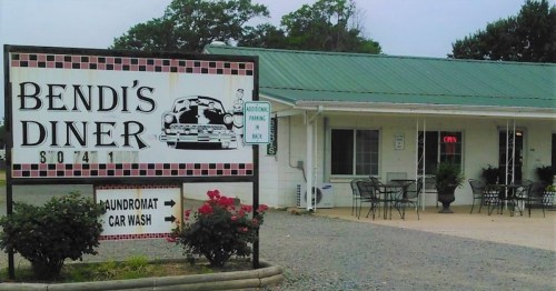 Sign for Bendi's Diner with a vintage car graphic, featuring outdoor seating and a laundromat and car wash nearby.