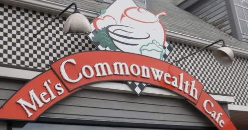 Sign for Mel's Commonwealth Café featuring a colorful design and checkered background.