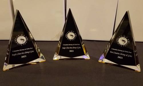 Three triangular awards with engraved text, labeled "People's Choice," "Judge's Choice," and "Best Creative," all from 2021.