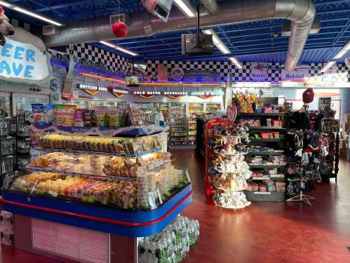 A colorful convenience store interior with snacks, drinks, and merchandise displayed on shelves and counters.