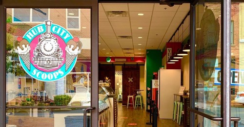 Entrance to Hub City Scoops, featuring a colorful logo and a view of the ice cream shop's interior.