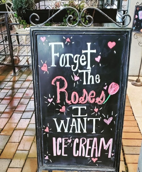 Chalkboard sign reads: "Forget the roses, I want ice cream" with decorative hearts and a flower illustration.