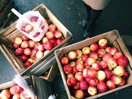 Baskets filled with red and yellow apples at a market, with a bag of apples nearby.