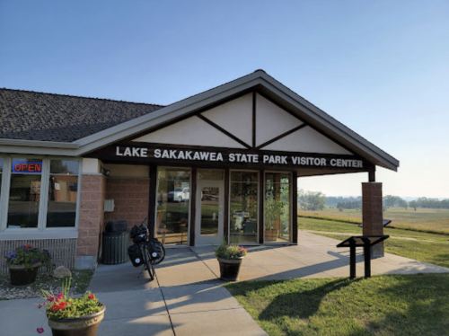 Exterior of Lake Sakakawea State Park Visitor Center, featuring large glass doors and a welcoming entrance.