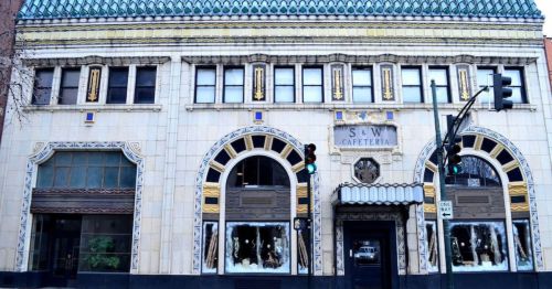 Historic building with ornate architecture, featuring a tiled roof and decorative facade, labeled "Cafeteria."