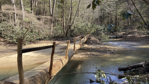 A rustic log bridge gives hikers a path over a river as seen from the Sheltowee Connector Trail in Kentucky.