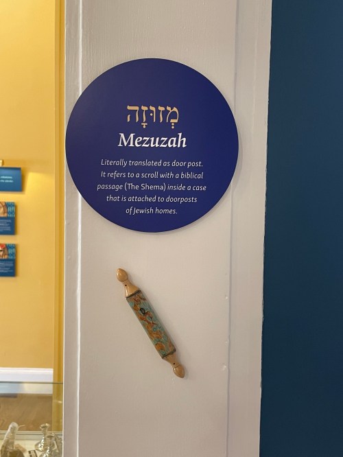 A sign explaining the mezuzah, a case containing a biblical passage, attached to a doorpost.