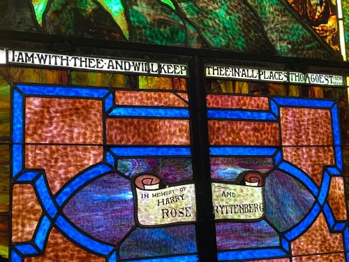Stained glass window featuring text: "I am with thee and will keep thee in all places thou goest." Memorial inscription below.