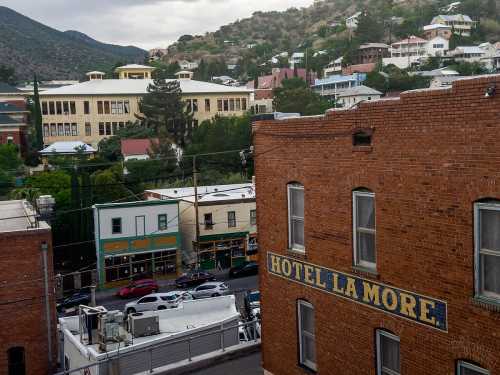 View of a historic town with the Hotel La More in the foreground and a large building in the background.