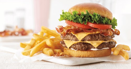 A juicy double cheeseburger with bacon, lettuce, and tomato, served with crispy fries on the side.