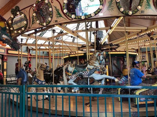 A colorful carousel with intricately designed horses and lights, featuring riders enjoying the ride.